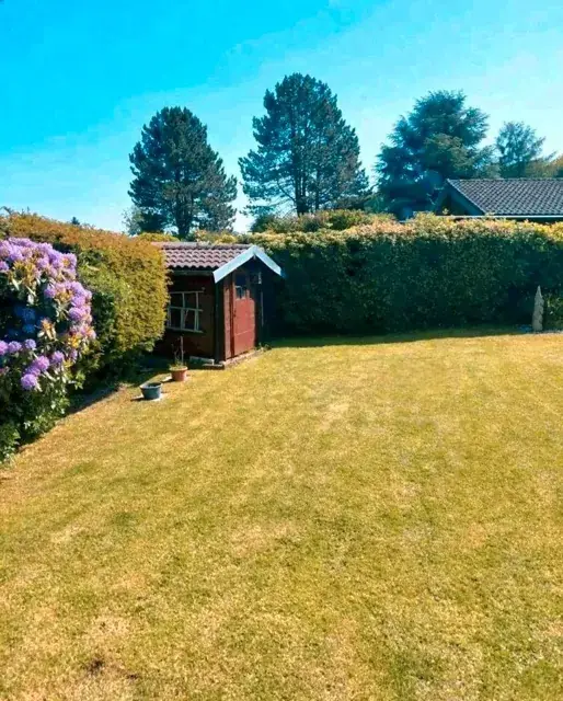 Gemähter Rasen vor einem Gartenhaus
